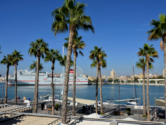 Hafenpromenade mit Palmen und Schiff in Malaga