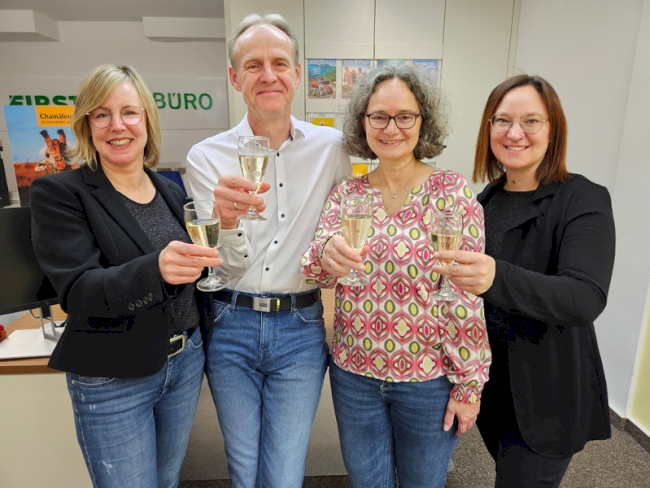 Reisebüroteam stösst mit Sekt an